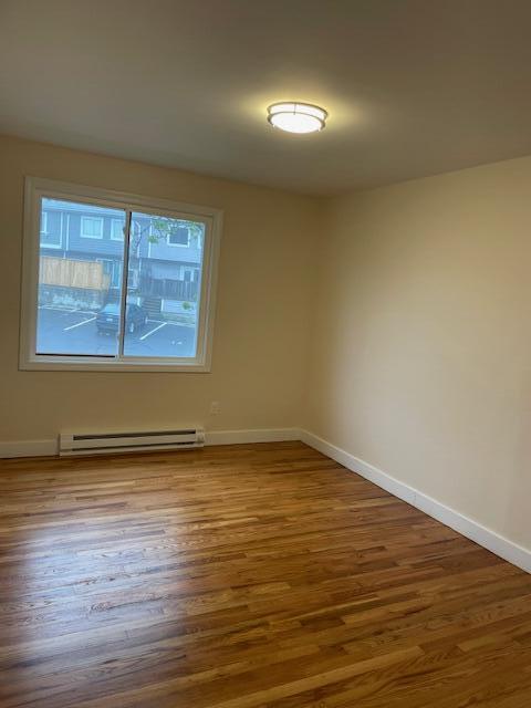 57 Mountfort St, Portland, ME 04101 - empty room featuring baseboard heating, wood finished floors, and baseboards