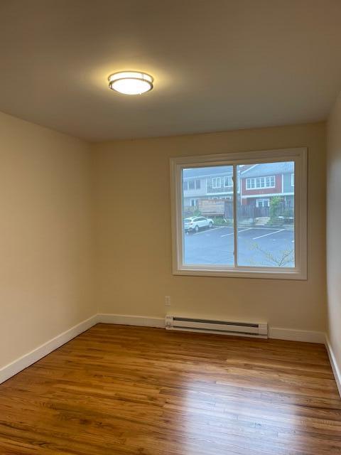 57 Mountfort St, Portland, ME 04101 - unfurnished room with a baseboard heating unit, baseboards, and wood finished floors