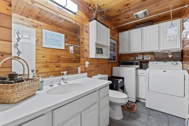 35 Burnt Mill Rd Unit B, Wells, ME 04090 - bathroom with separate washer and dryer, wood walls, tile patterned flooring, toilet, and vanity