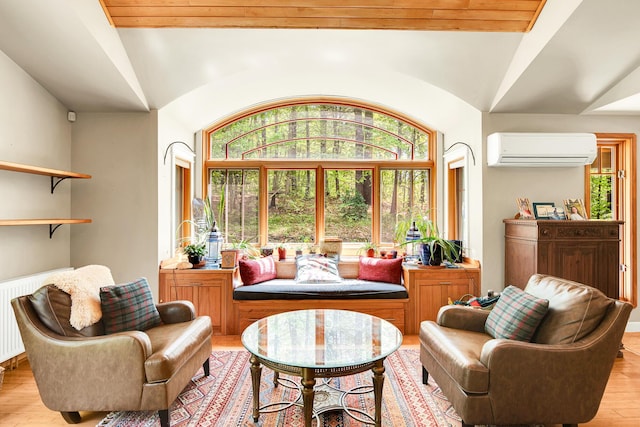 43 Creek Xing, Eliot, ME 03903 - living area with a wall mounted AC, vaulted ceiling, plenty of natural light, radiator heating unit, and light wood-style floors