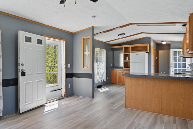 54 Whitten Rd, Clinton, ME 04927 - kitchen with freestanding refrigerator, light wood-style floors, ceiling fan, vaulted ceiling, and dark countertops