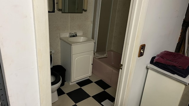 706 Crescent Ave, Rumford, ME 04276 - bathroom with tile patterned floors, toilet, vanity, tile walls, and shower / bathtub combination