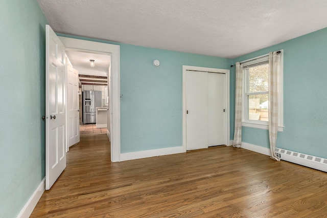 456 Ferry Rd, Saco, ME 04072 - unfurnished bedroom with stainless steel fridge with ice dispenser, wood finished floors, baseboards, and a textured ceiling