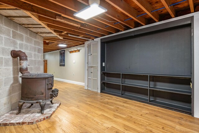 456 Ferry Rd, Saco, ME 04072 - finished basement with a wood stove, concrete block wall, and wood finished floors