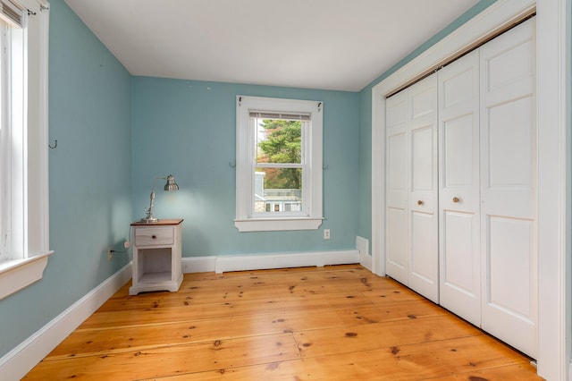 456 Ferry Rd, Saco, ME 04072 - unfurnished bedroom featuring baseboards, light wood finished floors, and a closet