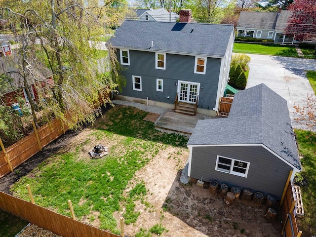 456 Ferry Rd, Saco, ME 04072 - rear view of house with a chimney, entry steps, roof with shingles, a fenced backyard, and a fire pit