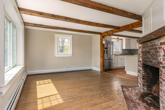 456 Ferry Rd, Saco, ME 04072 - unfurnished living room with a baseboard heating unit, beam ceiling, a sink, dark wood finished floors, and baseboards