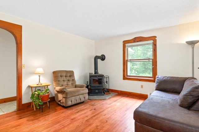 184 Long St, Limerick, ME 04048 - living room featuring a wood stove, light wood-style floors, and arched walkways