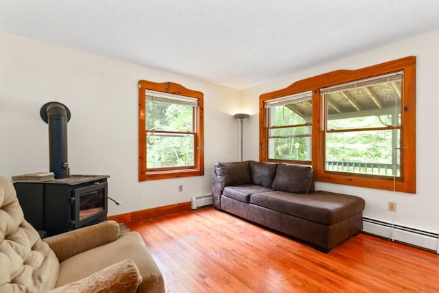 184 Long St, Limerick, ME 04048 - living area with healthy amount of natural light, baseboard heating, a wood stove, and wood finished floors