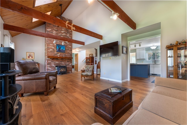 738 Litchfield Rd, Bowdoin, ME 04287 - living room with rail lighting, beam ceiling, light wood-type flooring, high vaulted ceiling, and stairs