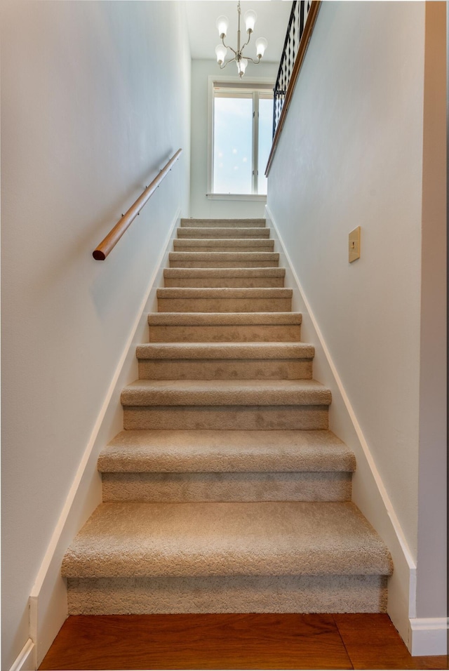 738 Litchfield Rd, Bowdoin, ME 04287 - staircase with wood finished floors and a chandelier
