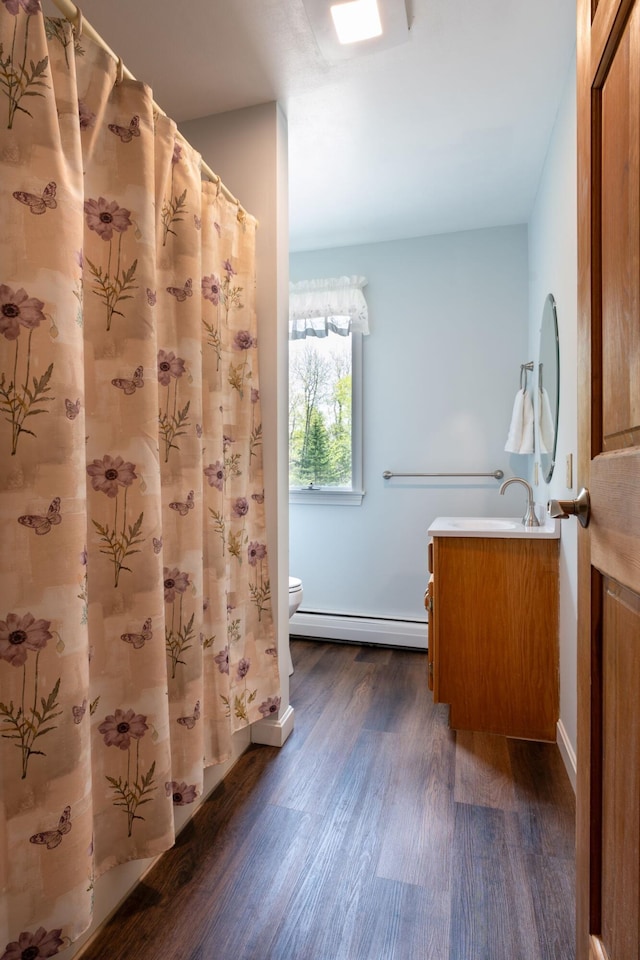 738 Litchfield Rd, Bowdoin, ME 04287 - bathroom featuring a baseboard radiator, wood finished floors, toilet, vanity, and baseboards