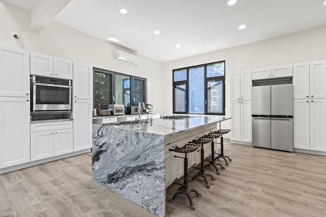5 Zakelo Island Rd, Harrison, ME 04040 - kitchen with appliances with stainless steel finishes, a wall mounted air conditioner, plenty of natural light, recessed lighting, and a kitchen breakfast bar