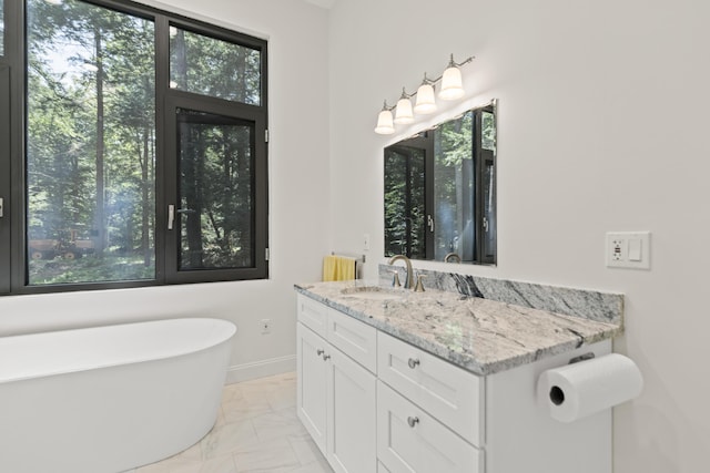 5 Zakelo Island Rd, Harrison, ME 04040 - full bathroom with marble look tiles, a freestanding tub, vanity, and baseboards