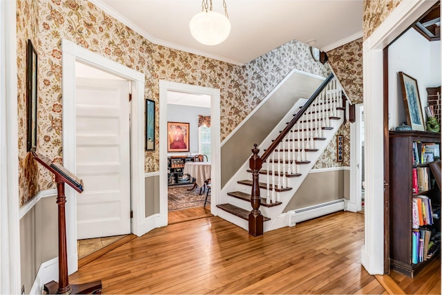 30 Morrill Ave, Waterville, ME 04901 - foyer entrance with wallpapered walls, a baseboard radiator, stairs, hardwood / wood-style floors, and crown molding