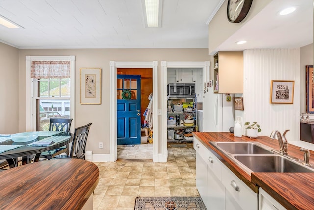 30 Morrill Ave, Waterville, ME 04901 - kitchen with butcher block countertops, a sink, stainless steel microwave, freestanding refrigerator, and ornamental molding