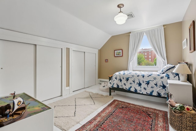 377 Cumberland Ave, Portland, ME 04101 - bedroom featuring multiple closets, lofted ceiling, and a baseboard heating unit