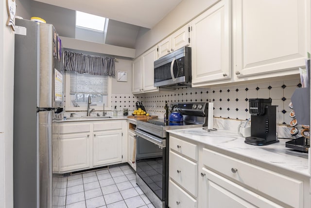 6 Linwood Rd Unit 6, Freeport, ME 04032 - kitchen featuring stainless steel appliances, a sink, white cabinetry, light tile patterned floors, and tasteful backsplash