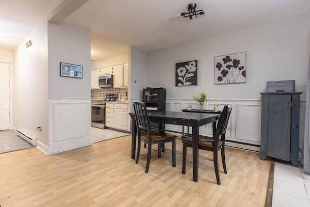 6 Linwood Rd Unit 6, Freeport, ME 04032 - dining space featuring light wood finished floors, a baseboard heating unit, wainscoting, and a decorative wall