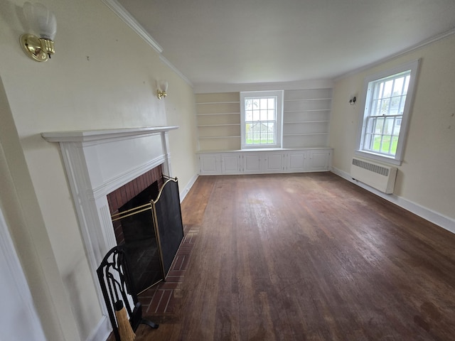 22 Summer St, Lubec, ME 04652 - unfurnished living room with radiator, wood finished floors, a brick fireplace, built in shelves, and baseboards