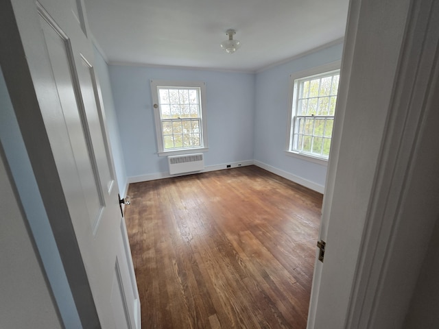 22 Summer St, Lubec, ME 04652 - empty room with radiator, crown molding, dark wood-style floors, and baseboards