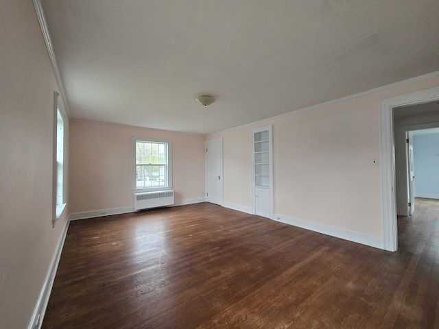22 Summer St, Lubec, ME 04652 - unfurnished room featuring radiator heating unit, dark wood-style flooring, crown molding, baseboards, and built in shelves