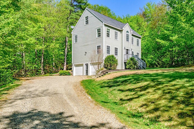 9 Eisenhower Ct, Naples, ME 04055 - view of front of home with an attached garage, dirt driveway, a front lawn, a forest view, and stairs