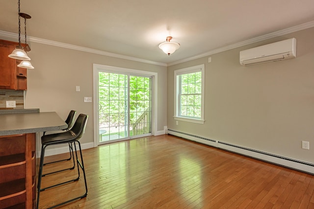 9 Eisenhower Ct, Naples, ME 04055 - dining area featuring a wall mounted AC, a baseboard radiator, light wood finished floors, crown molding, and baseboards