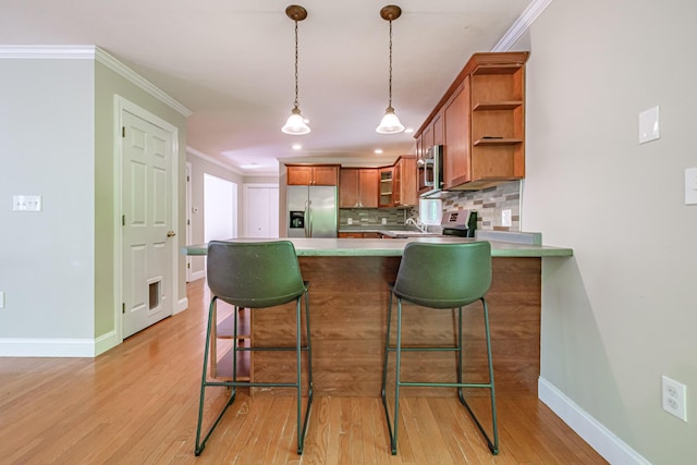 9 Eisenhower Ct, Naples, ME 04055 - kitchen with appliances with stainless steel finishes, brown cabinets, a peninsula, decorative backsplash, and baseboards