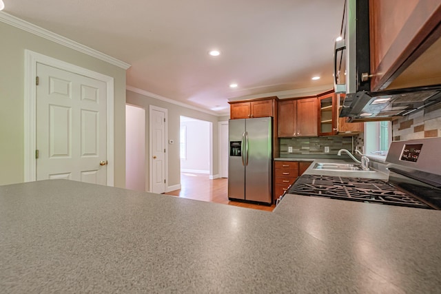 9 Eisenhower Ct, Naples, ME 04055 - kitchen with stainless steel appliances, a sink, brown cabinetry, ornamental molding, and tasteful backsplash