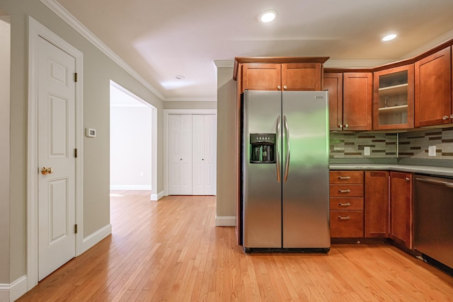 9 Eisenhower Ct, Naples, ME 04055 - kitchen with stainless steel appliances, ornamental molding, brown cabinetry, light wood-style flooring, and decorative backsplash