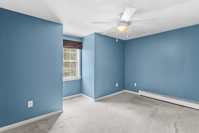 carpeted spare room with a ceiling fan and baseboards