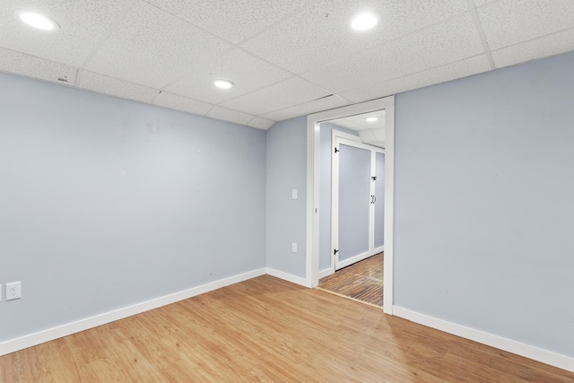 spare room featuring light wood finished floors, baseboards, recessed lighting, and a paneled ceiling