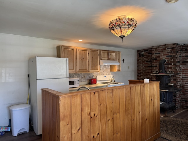 4 Main St, Saint Albans, ME 04971 - kitchen featuring white appliances, a wood stove, under cabinet range hood, backsplash, and light countertops