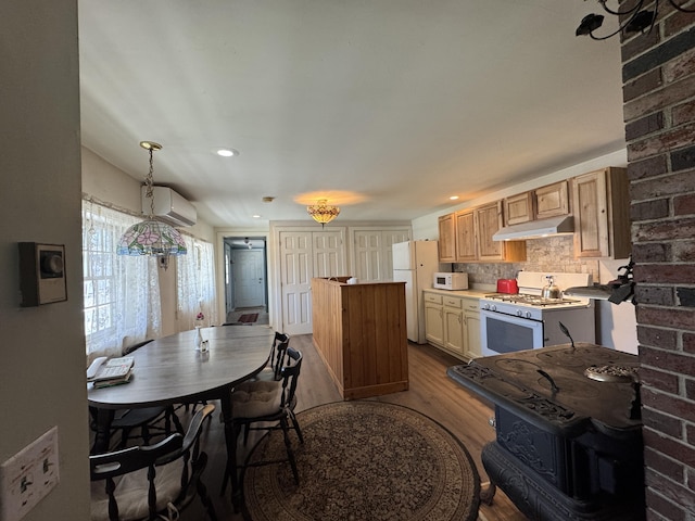 4 Main St, Saint Albans, ME 04971 - kitchen with white appliances, under cabinet range hood, dark wood-style floors, an AC wall unit, and a center island