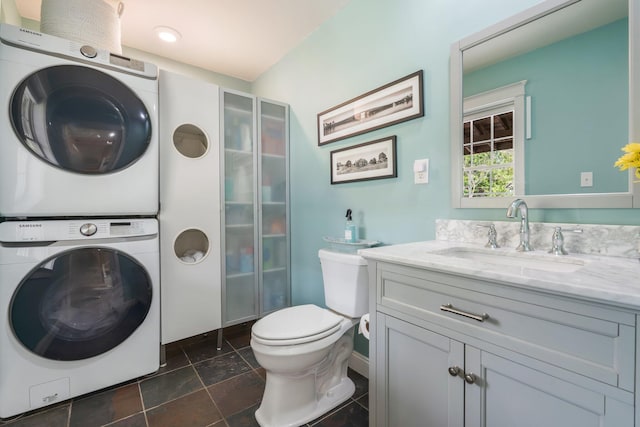 603 S Freedom Rd, Albion, ME 04910 - full bathroom featuring estacked washer and dryer, toilet, vanity, and baseboards