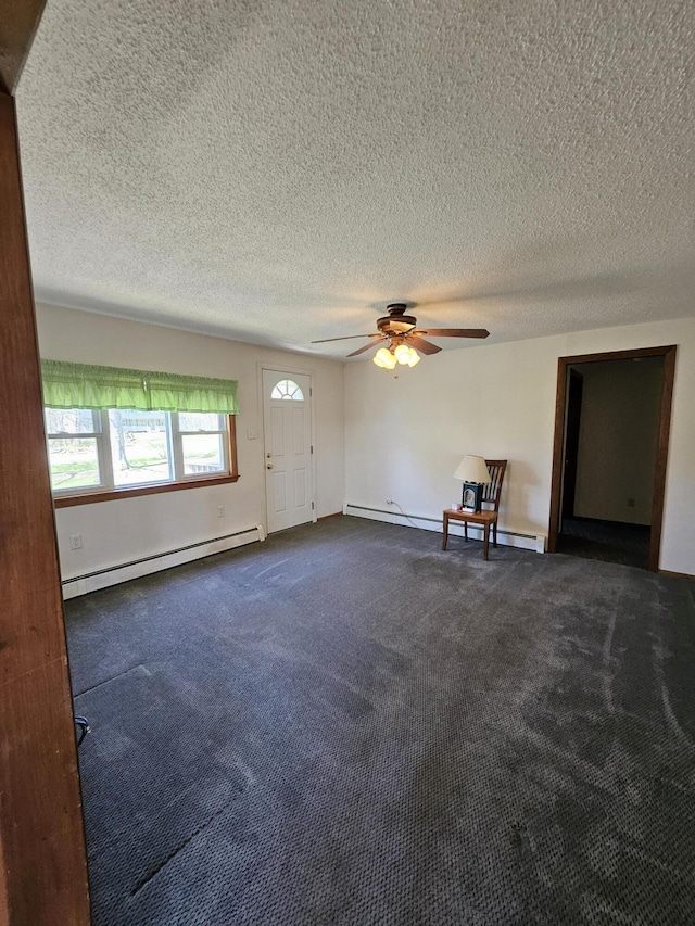 1377 Pushaw Rd, Glenburn, ME 04401 - spare room featuring a baseboard radiator, dark colored carpet, ceiling fan, and a textured ceiling
