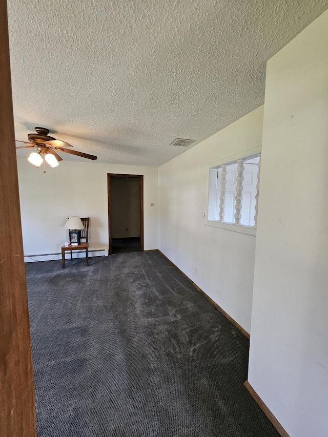 1377 Pushaw Rd, Glenburn, ME 04401 - empty room featuring dark carpet, a textured ceiling, ceiling fan, and baseboards