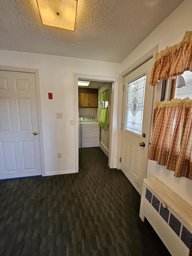 1377 Pushaw Rd, Glenburn, ME 04401 - foyer with radiator, washing machine and dryer, a textured ceiling, baseboards, and dark wood finished floors