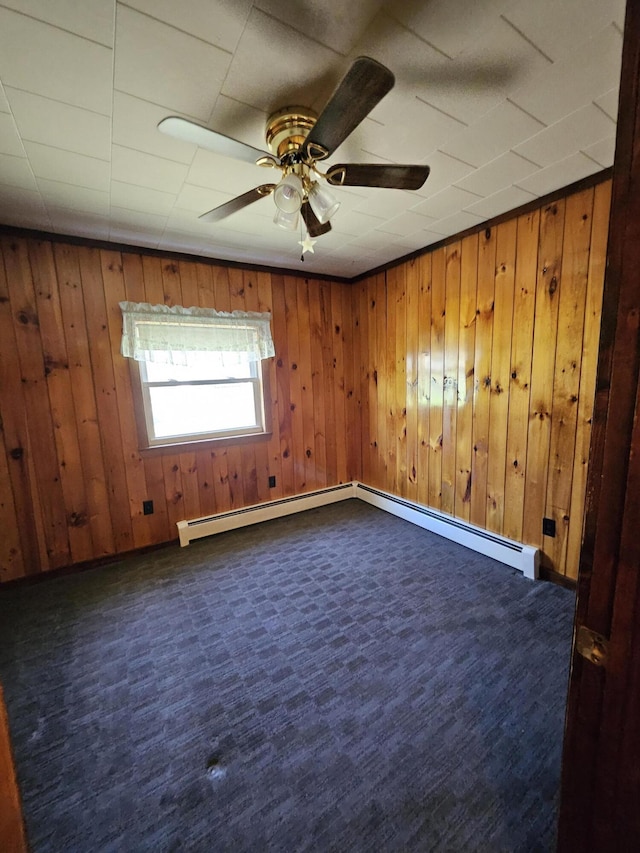 1377 Pushaw Rd, Glenburn, ME 04401 - unfurnished room featuring dark carpet, ceiling fan, wooden walls, and a baseboard radiator