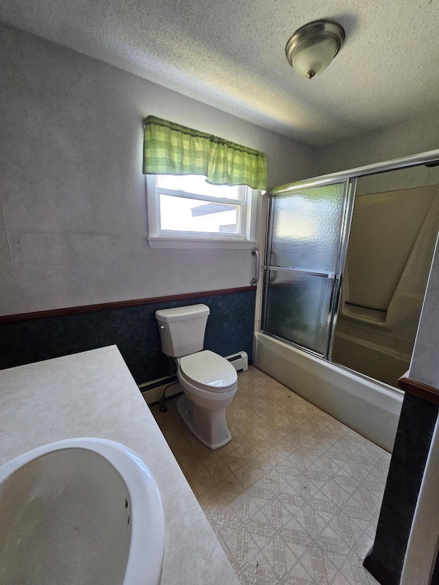 1377 Pushaw Rd, Glenburn, ME 04401 - bathroom featuring a sink, toilet, combined bath / shower with glass door, baseboard heating, and a textured ceiling