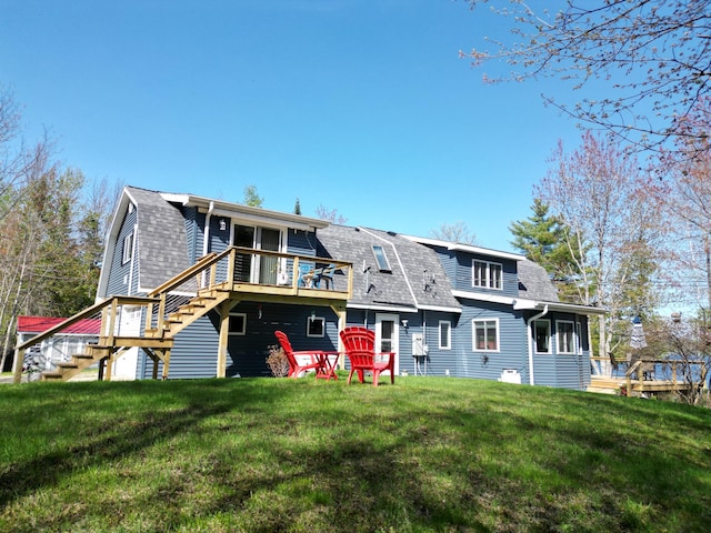 11 Beethoven Ln, Enfield, ME 04493 - back of property with a gambrel roof, a deck, a yard, roof with shingles, and stairs