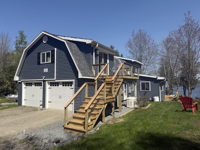 11 Beethoven Ln, Enfield, ME 04493 - back of property with a lawn, a garage, a deck, stairs, and a gambrel roof