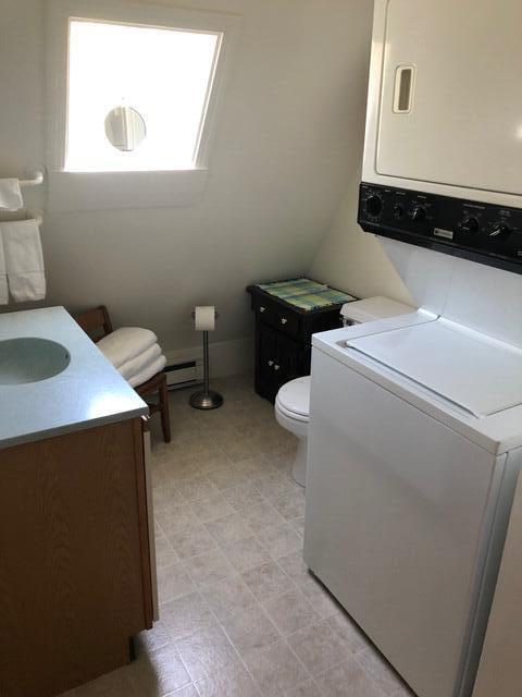 11 Beethoven Ln, Enfield, ME 04493 - washroom featuring stacked washer / dryer and a baseboard radiator