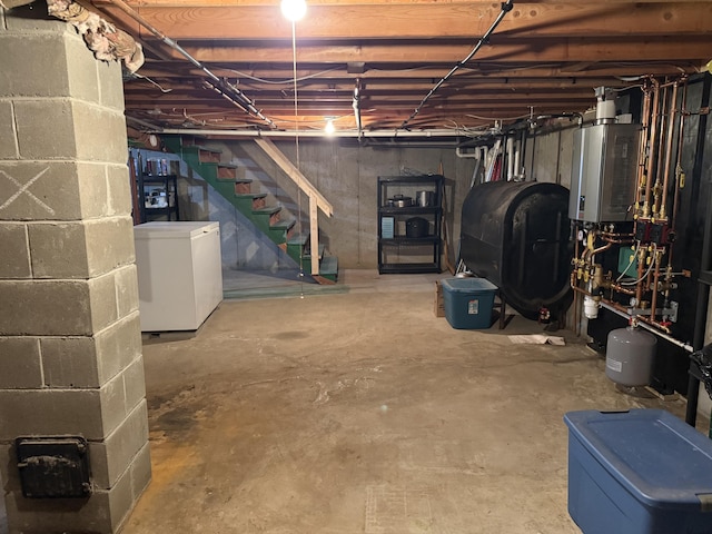 11 Beethoven Ln, Enfield, ME 04493 - unfinished below grade area featuring oil tank, refrigerator, and stairway
