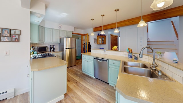 11 Beethoven Ln, Enfield, ME 04493 - kitchen with appliances with stainless steel finishes, a baseboard heating unit, blue cabinets, a sink, and decorative backsplash