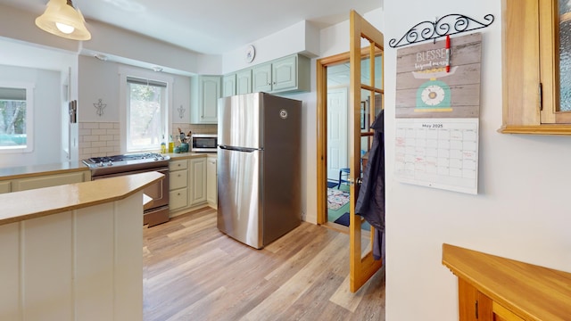 11 Beethoven Ln, Enfield, ME 04493 - kitchen with appliances with stainless steel finishes, light countertops, light wood-style floors, and tasteful backsplash