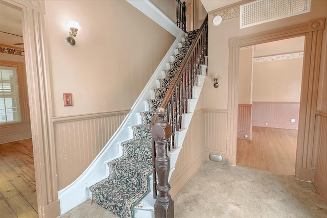 77 Cottage St, Bangor, ME 04401 - stairway featuring a wainscoted wall, wood-type flooring, and a decorative wall