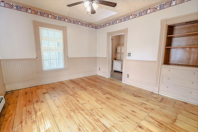 77 Cottage St, Bangor, ME 04401 - spare room with wainscoting, a ceiling fan, wood-type flooring, and a baseboard radiator