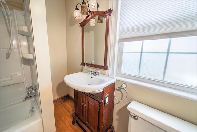 77 Cottage St, Bangor, ME 04401 - bathroom with toilet, wood finished floors, vanity, shower / bathtub combination, and baseboards